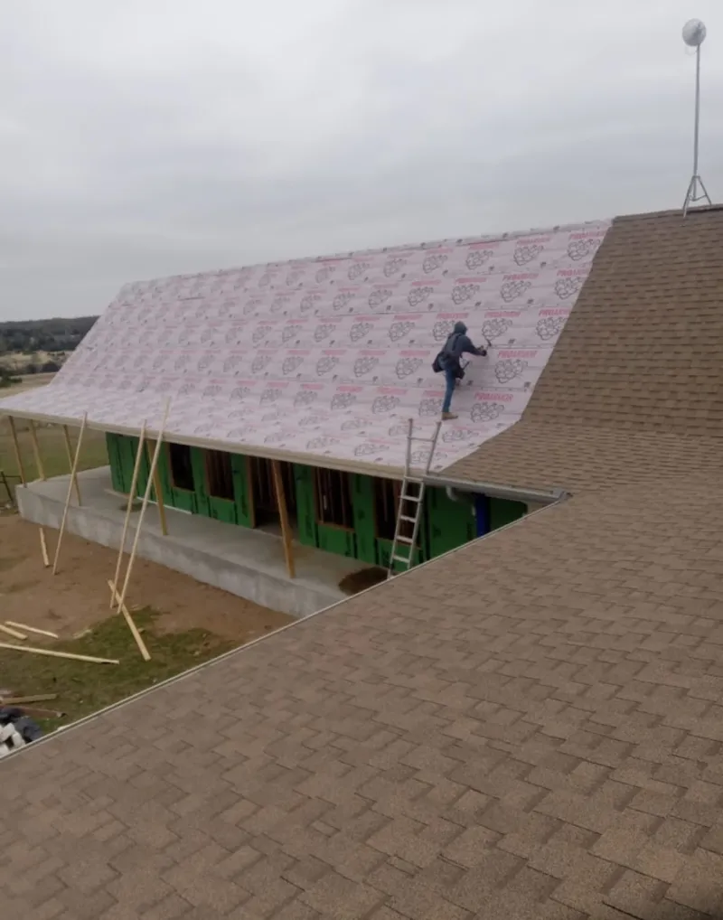 Worker preparing underlayment for a metal roof installation in Tarpon Springs